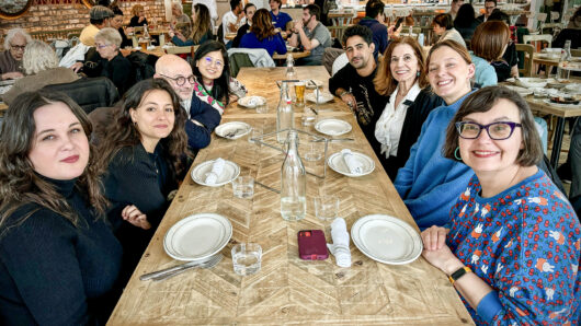 a group of 8 people at a restaurant sitting around a table