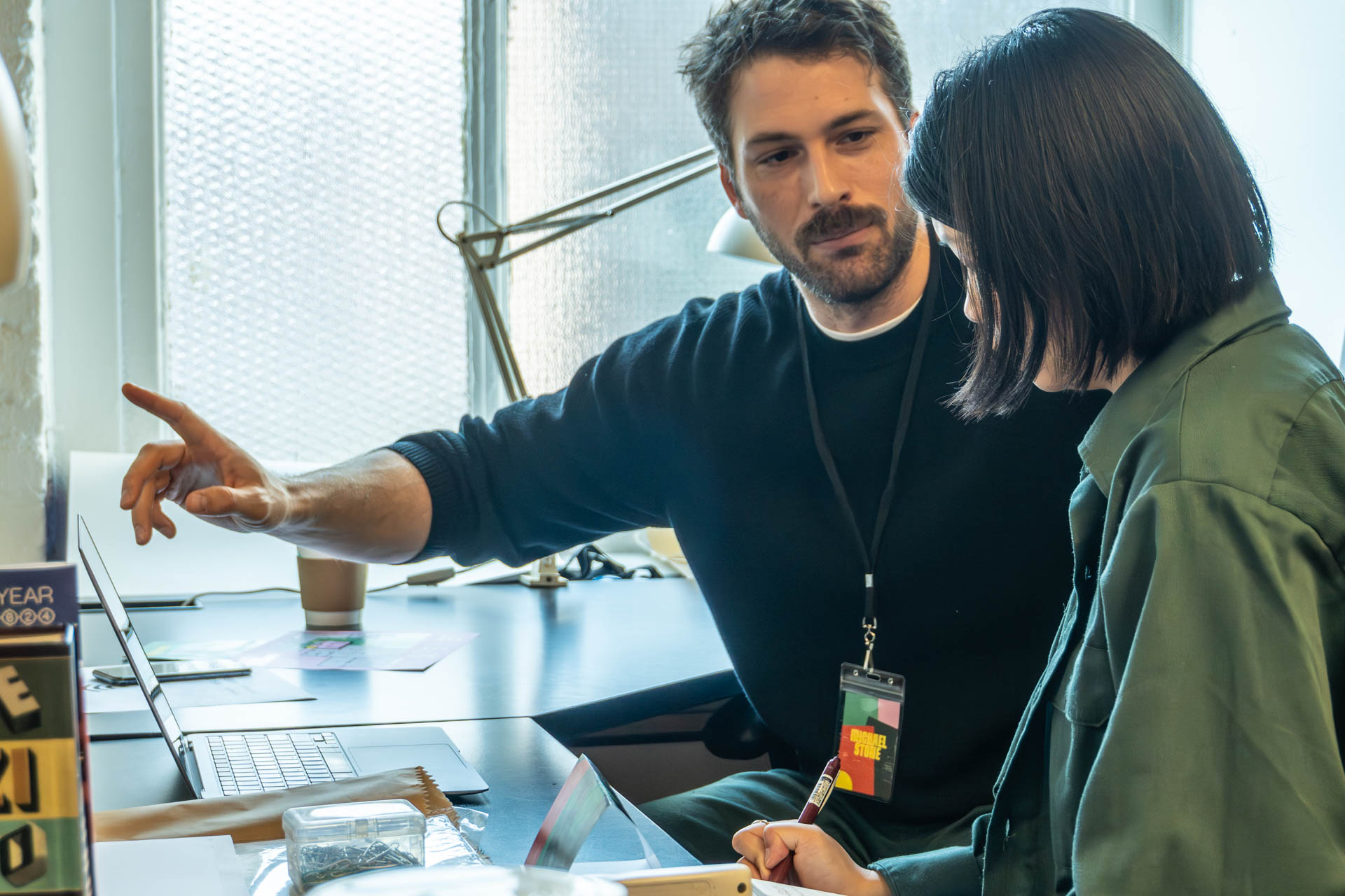 two people talking and looking at a computer