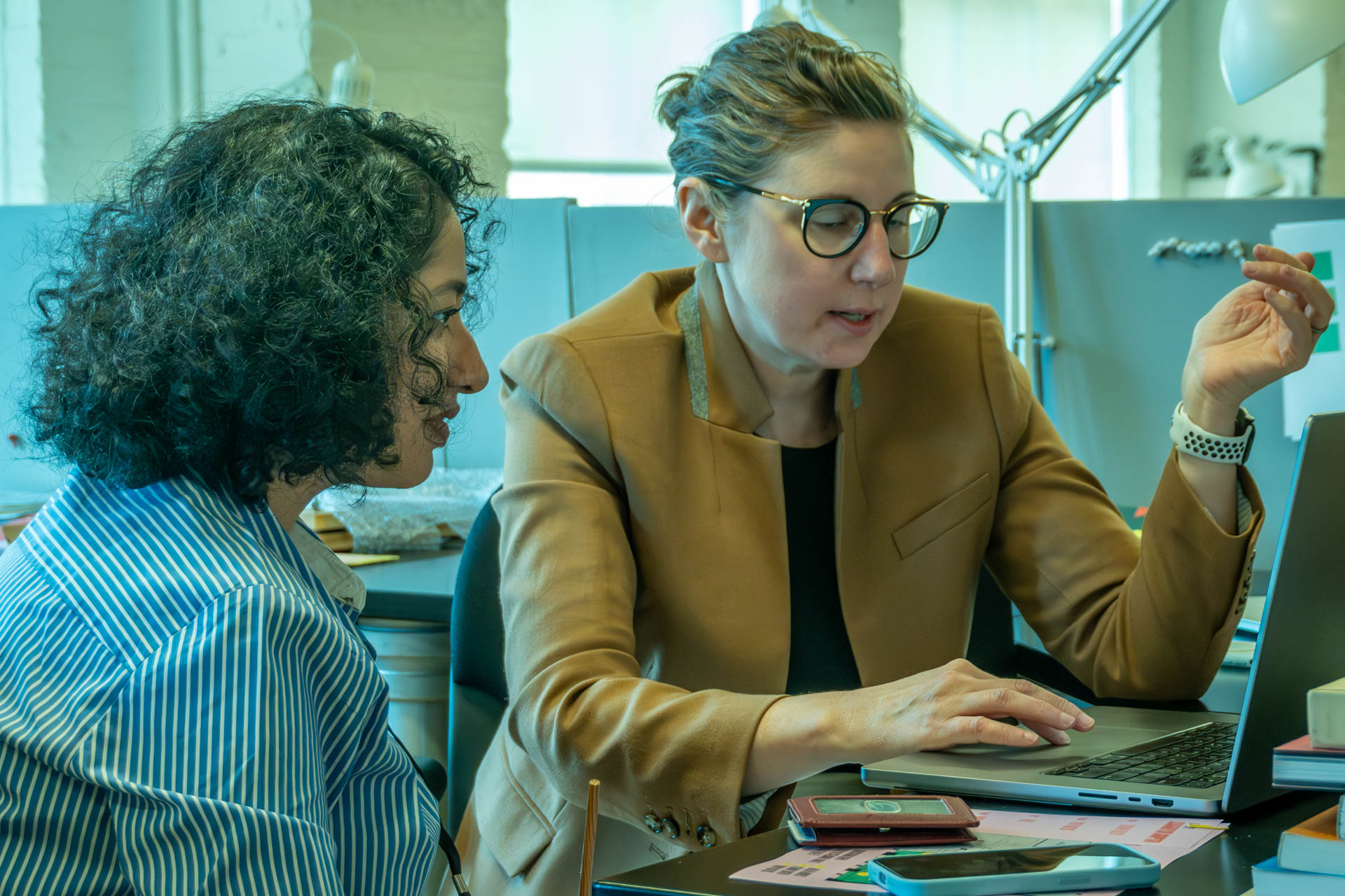 two people talking and looking at a computer