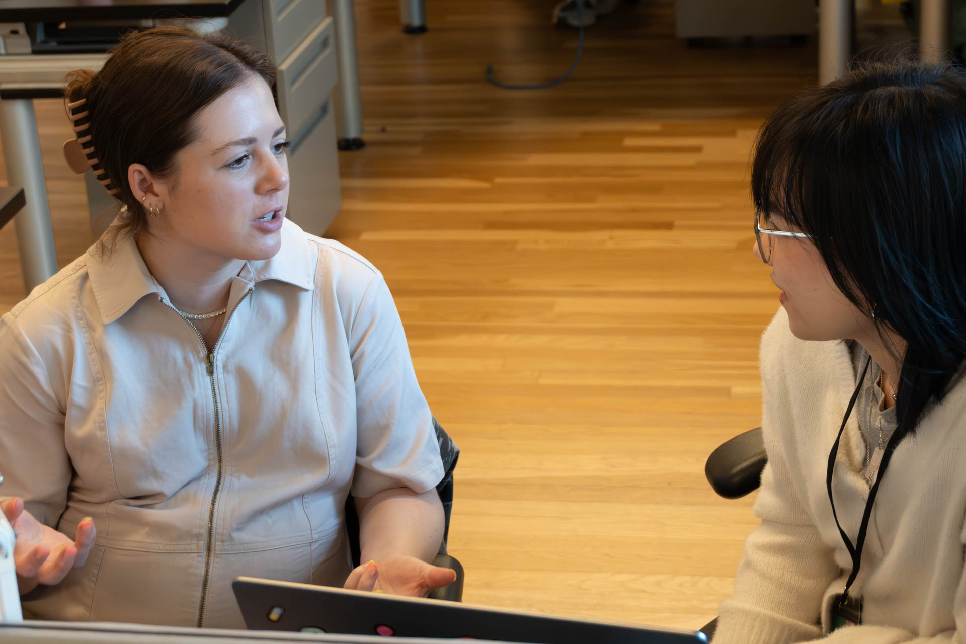 two people talking and looking at a computer