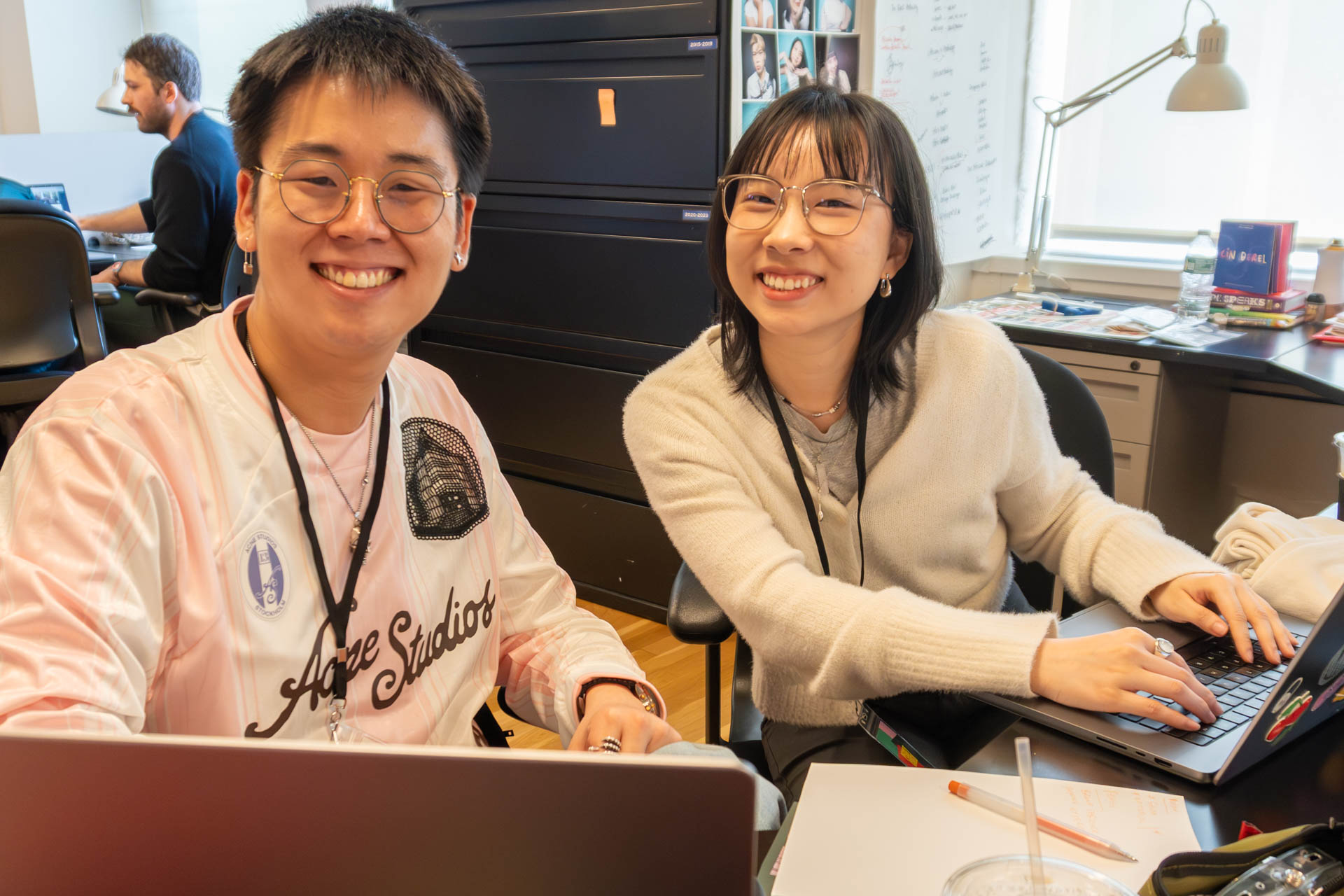 two people talking and looking at a computer