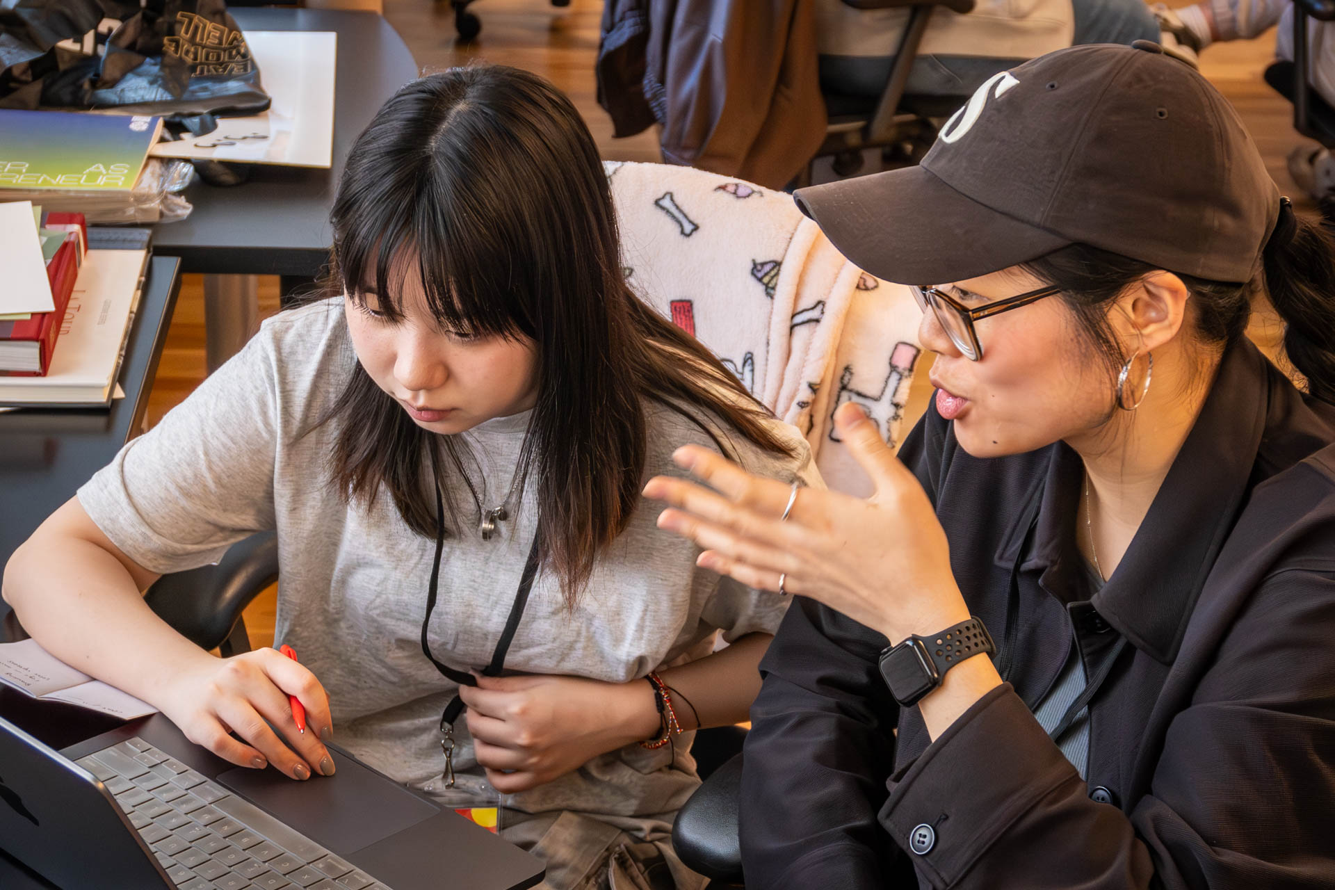 two people talking and looking at a computer