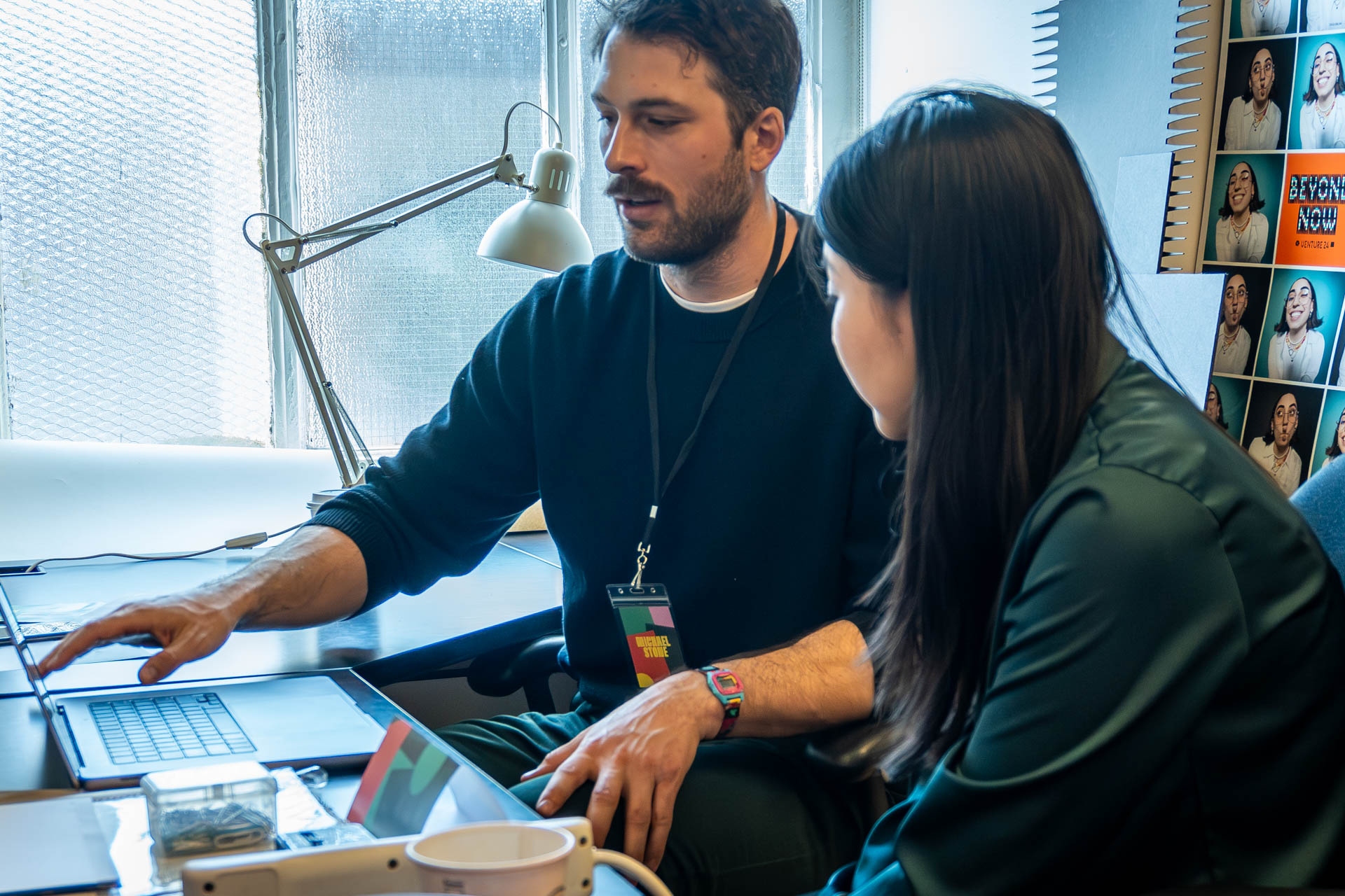 two people talking and looking at a computer