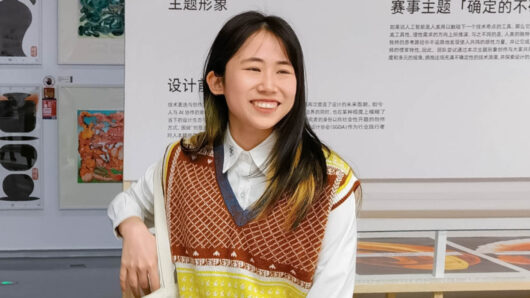 a woman with long hair in front of a museum display