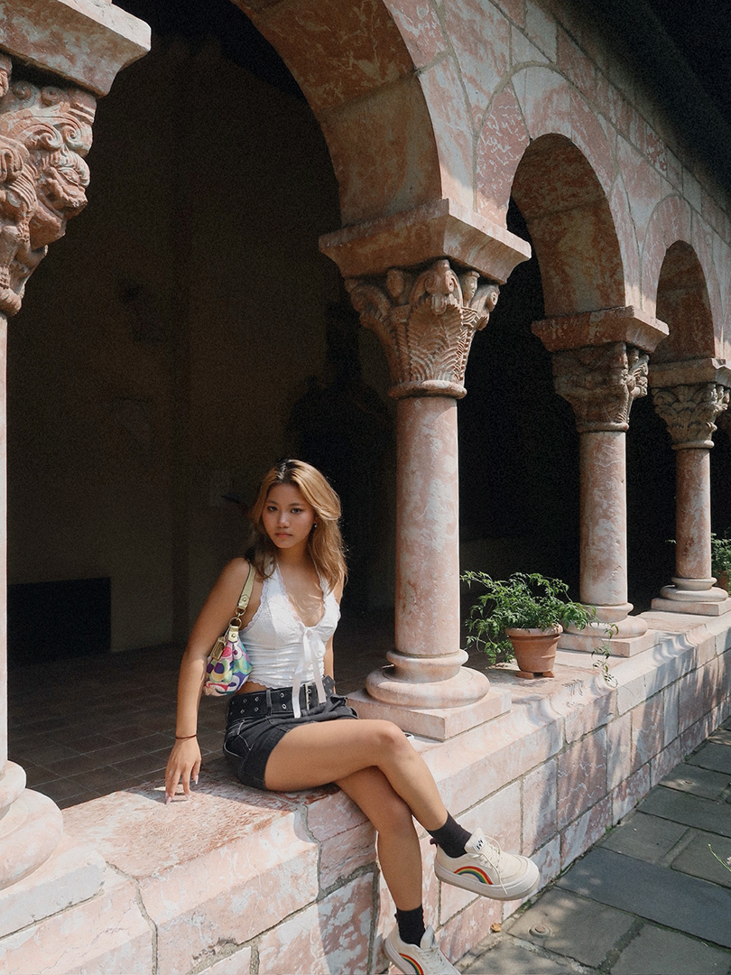 woman with long hair sitting in a colonade