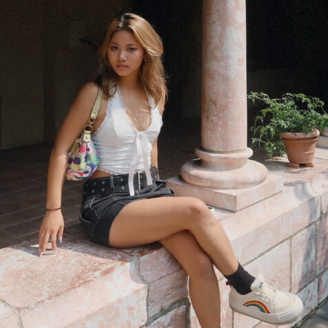 woman with long hair sitting in a colonade