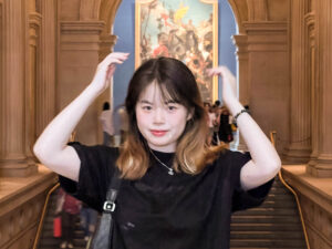 a woman in a marble room with hands above her head