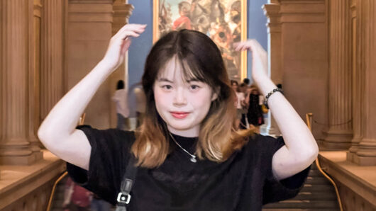 a woman in a marble room with hands above her head