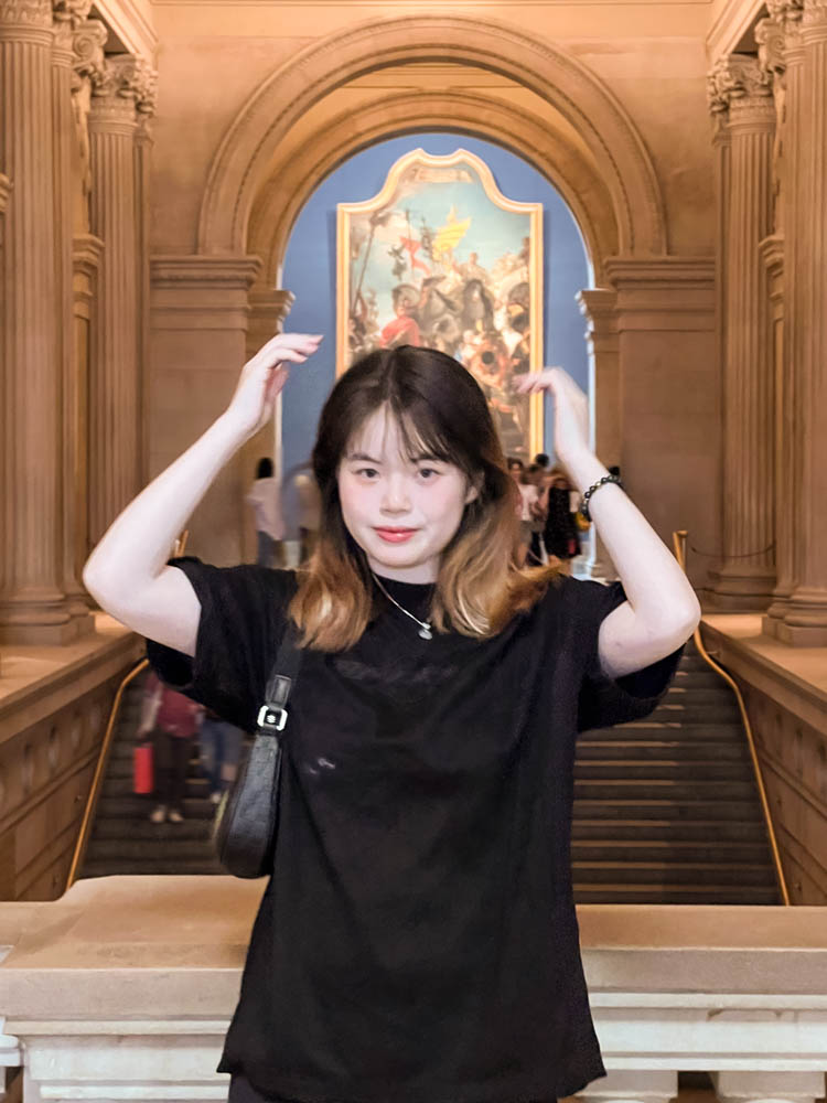 a woman in a marble room with hands above her head -square photo