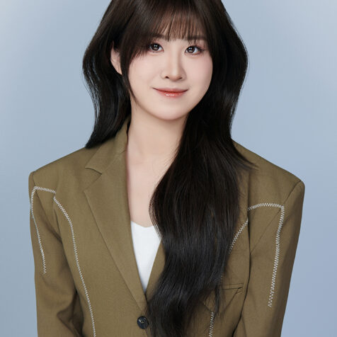 an photo of a young woman in a brown suit jacket, long hair