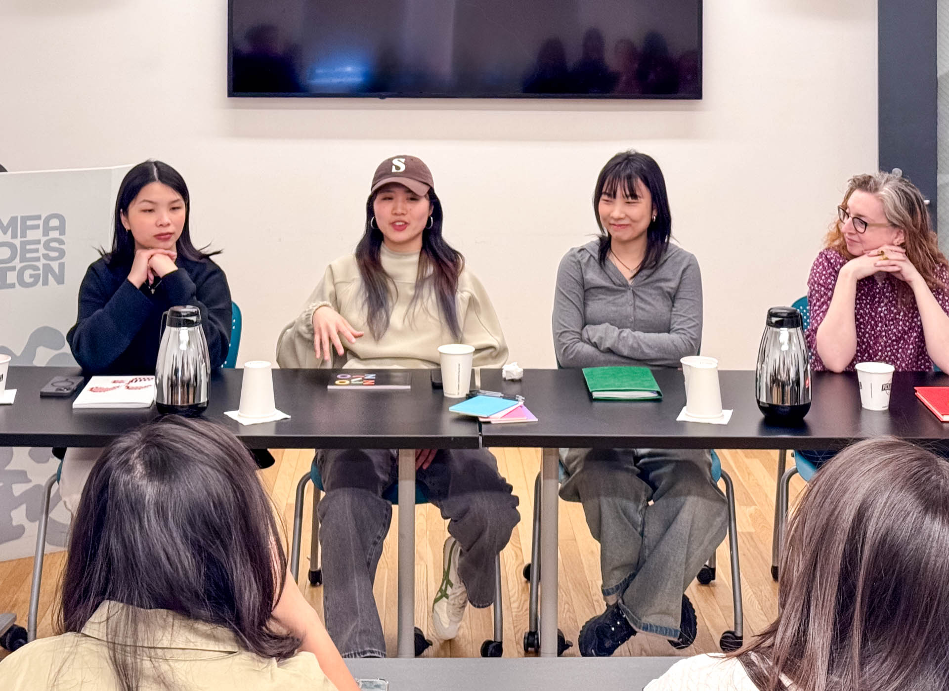 a panel of four women speak to a class of people at their desks