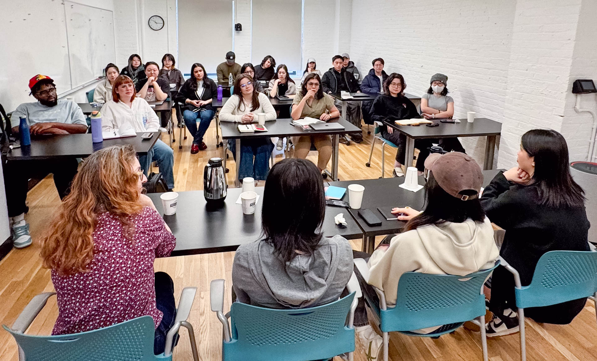 a panel of four women speak to a class of people at their desks