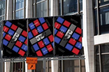 three red and blue posters outside in front of a building.