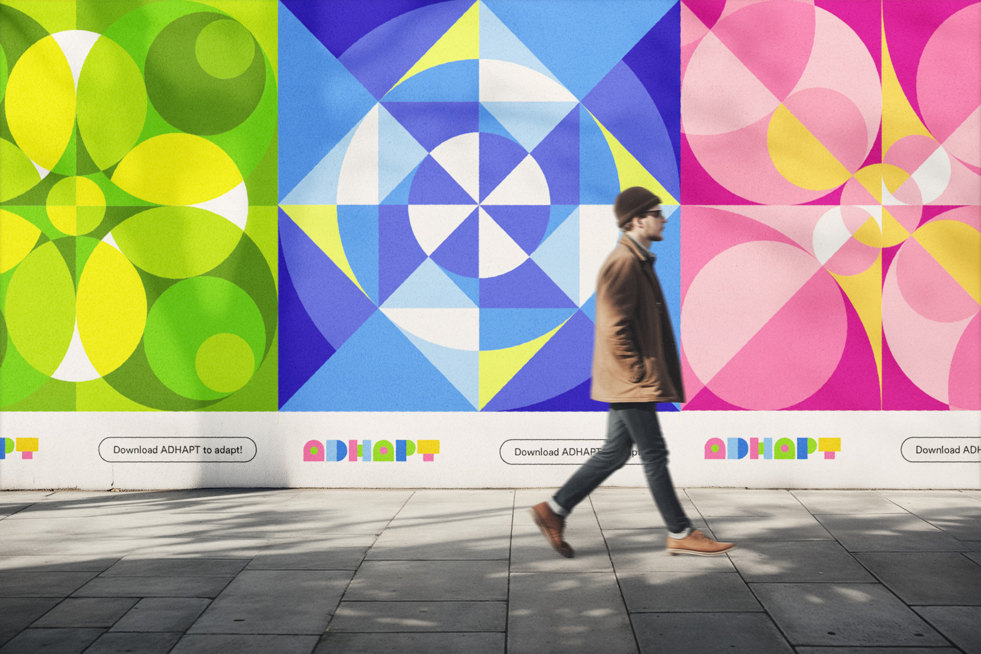 a man walking by advertisements on the street walls. the posters show large geometric shapes