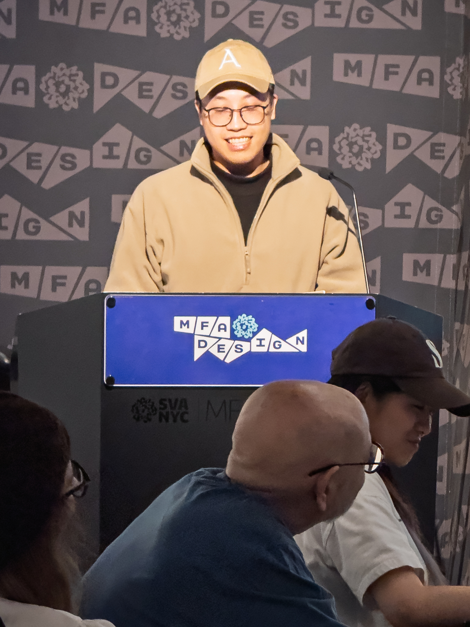 Woman at a podium with microphone, delivering a slide presentation