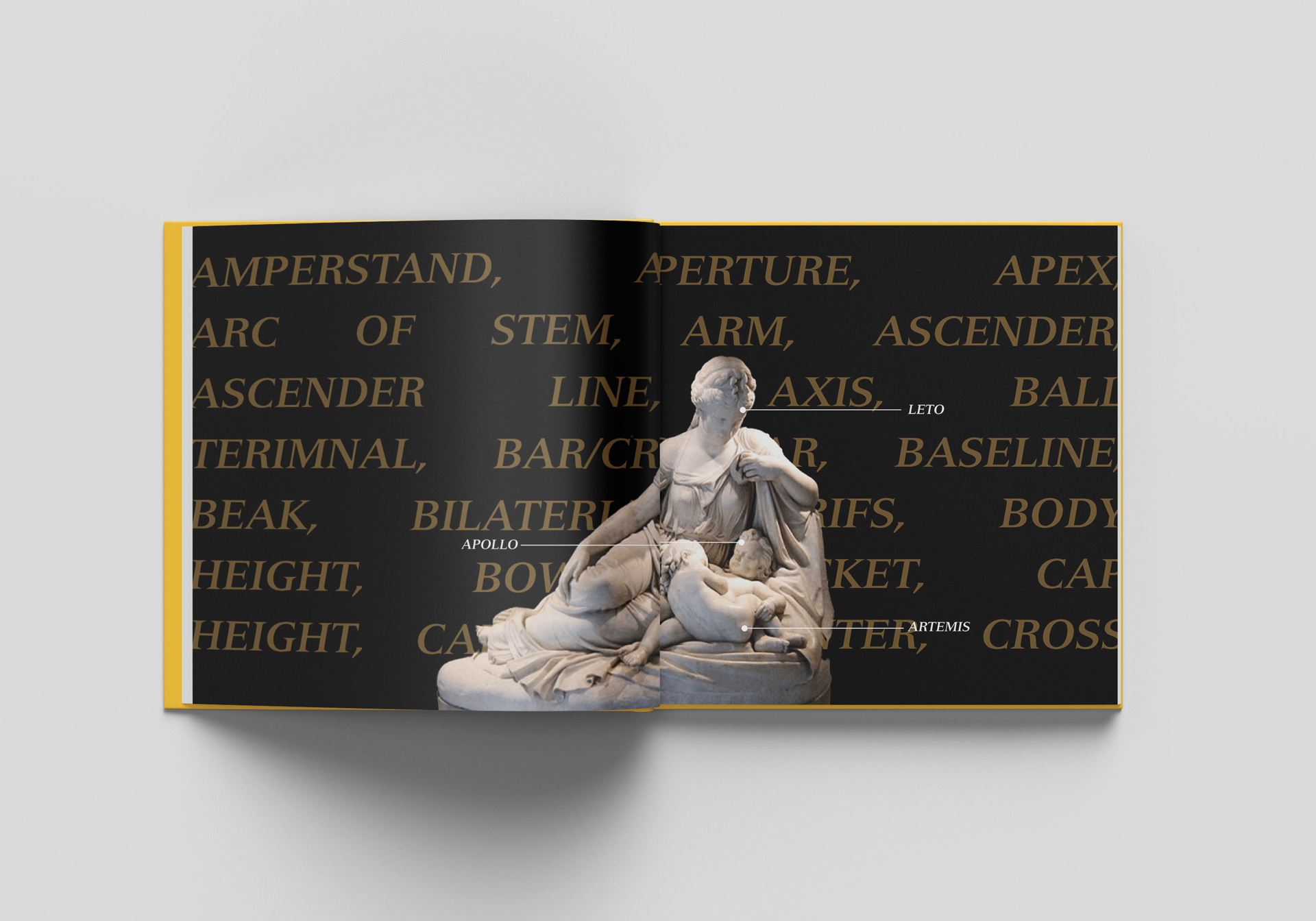 book open on a white table showing a photo of a sculpture and words around it.