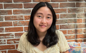 portrait of a woman with long hair against a brick wall background