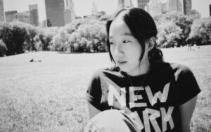 woman looking off camera in a park with a New York City t-shirt