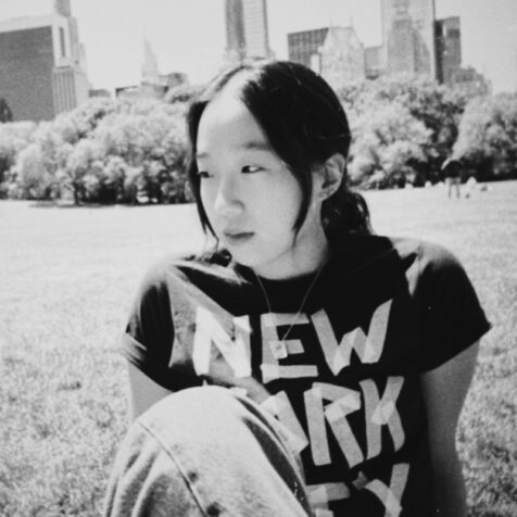 woman looking off camera in a park with a New York City t-shirt