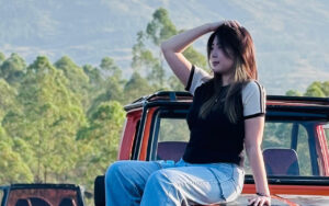 woman on the hood of a car outside in nature