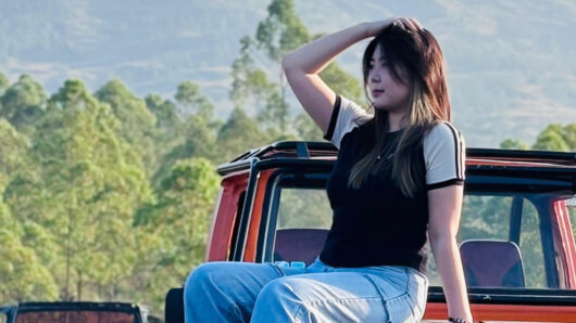 woman on the hood of a car outside in nature