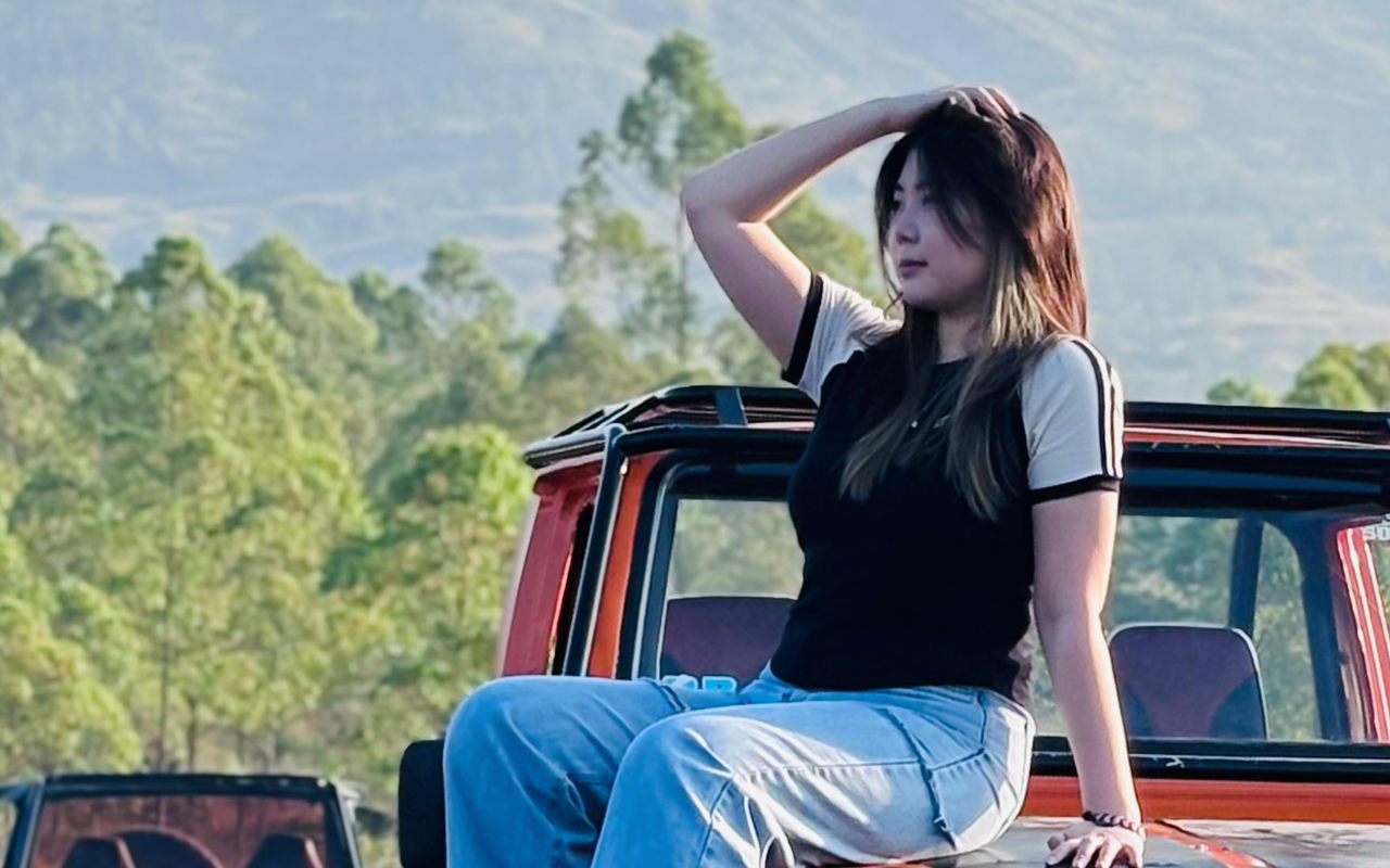 woman on the hood of a car outside in nature