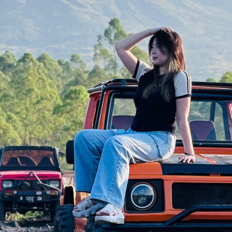 woman on the hood of a car outside in nature