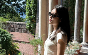 a woman with long hair and sunglasses in a courtyard