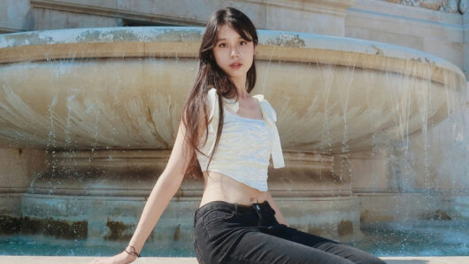 portrait of a woman with long hair in front of a fountain