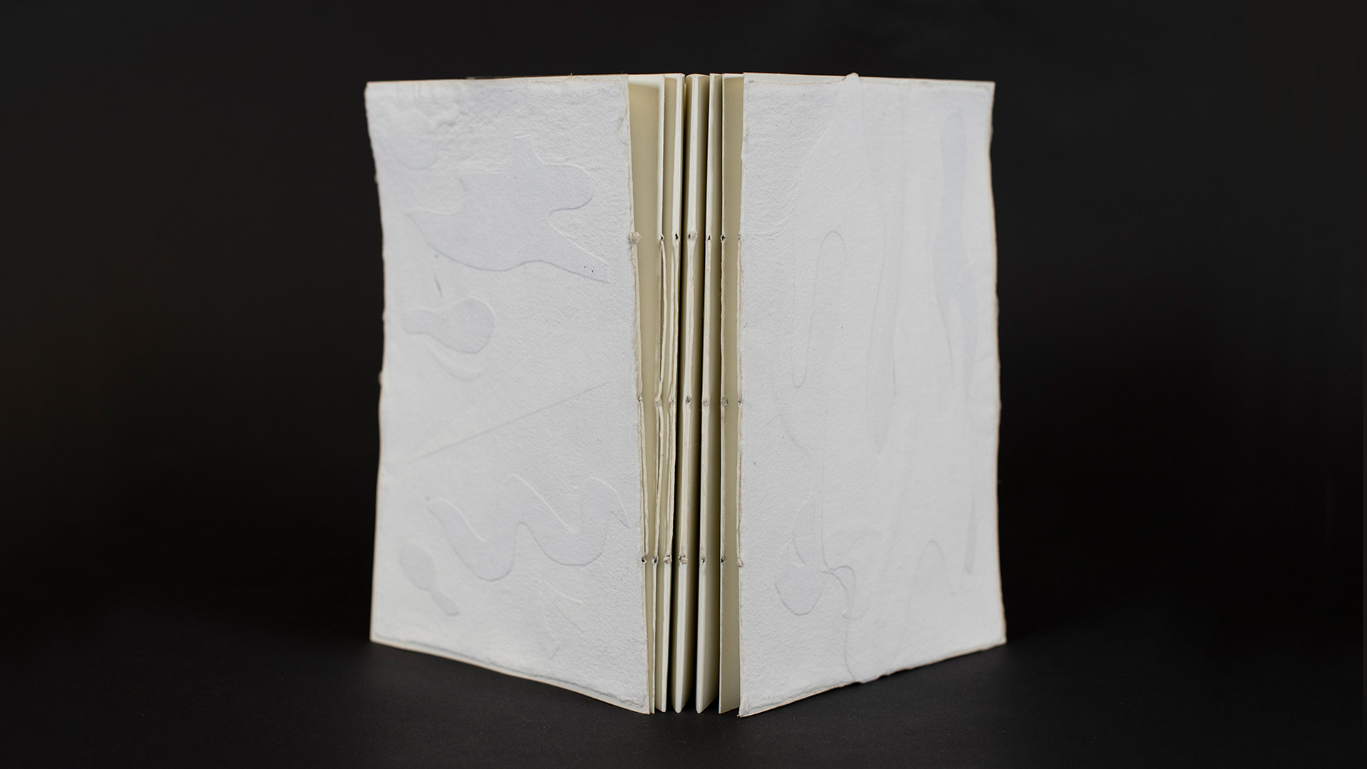 book on black background open to show handmade spine.