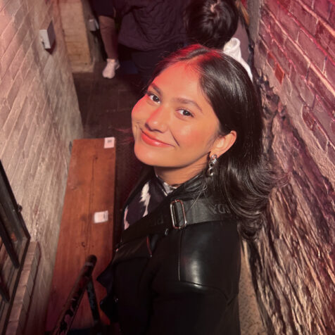 a portrait of a smiling woman in a brick alleyway