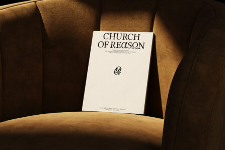 Minimal magazine cover reading “CHURCH OF REASON” placed on a brown upholstered chair in warm lighting.