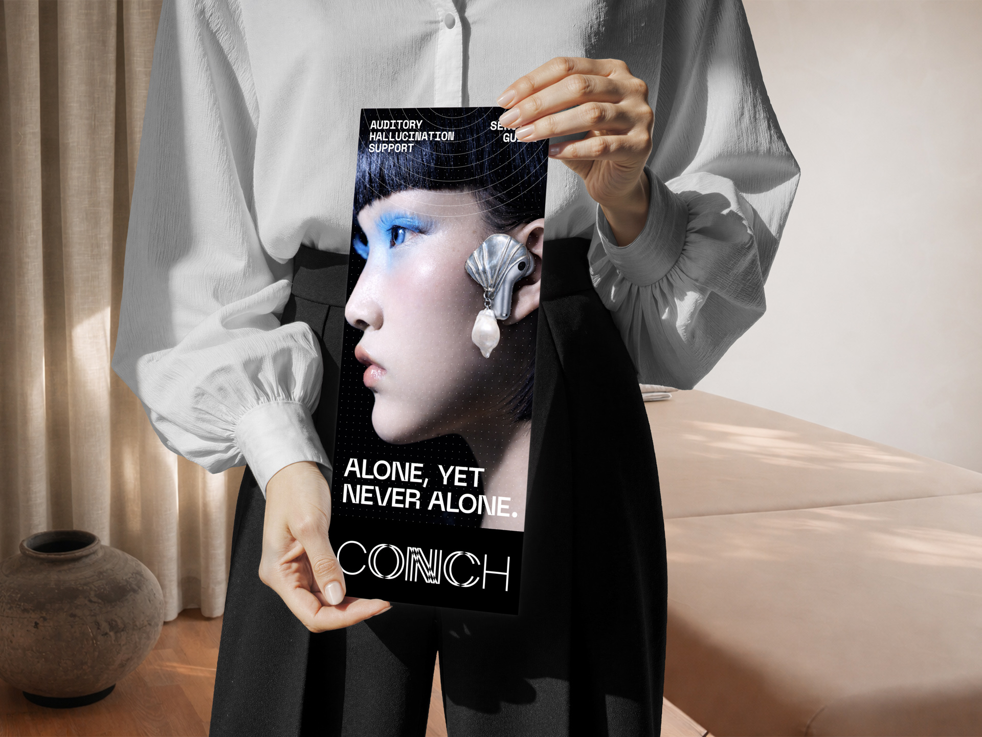 Person holding a tall CONCH promotional flyer featuring a stylized portrait and the text “Alone, yet never alone.”