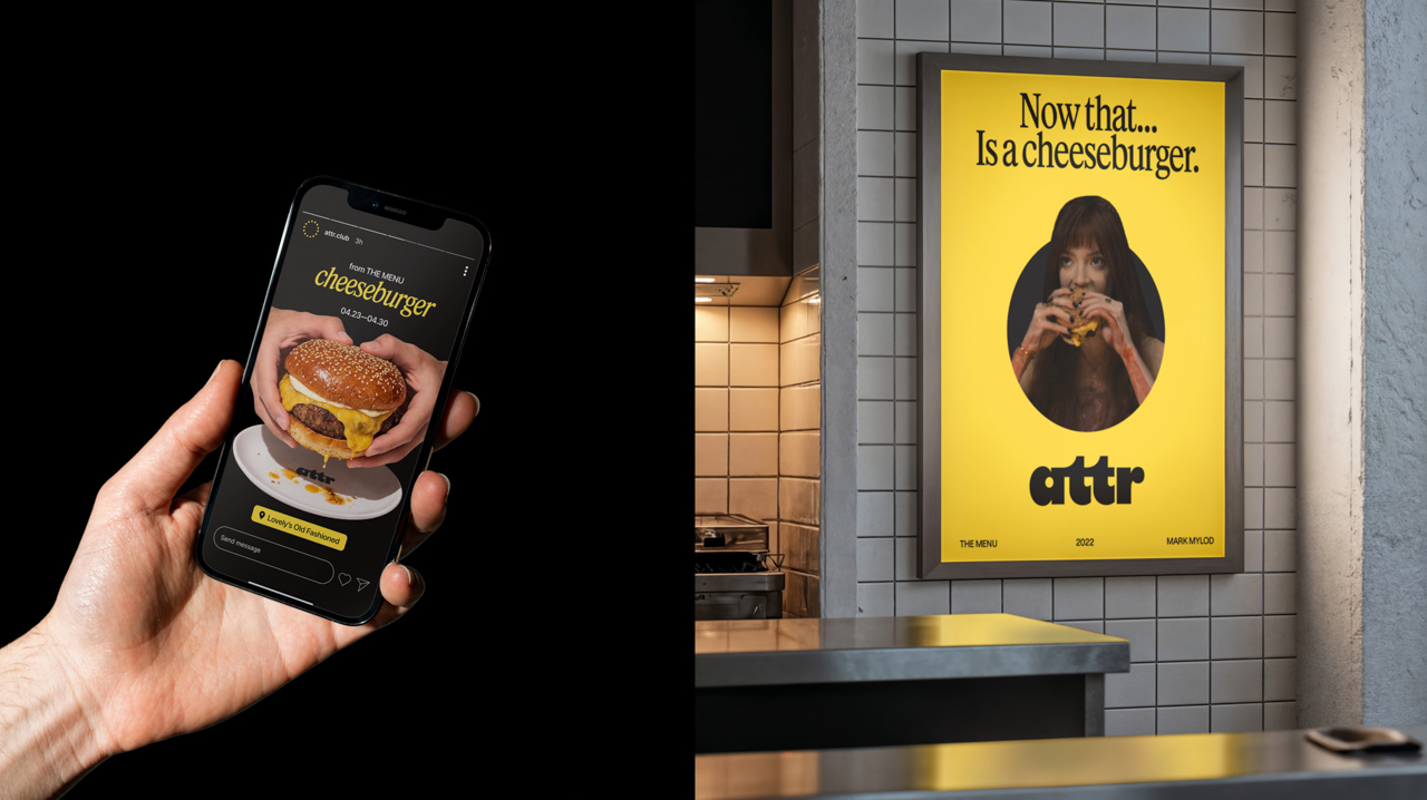 Hand holding a smartphone displaying a cheeseburger advertisement beside a yellow restaurant poster reading “Now that… Is a cheeseburger.”