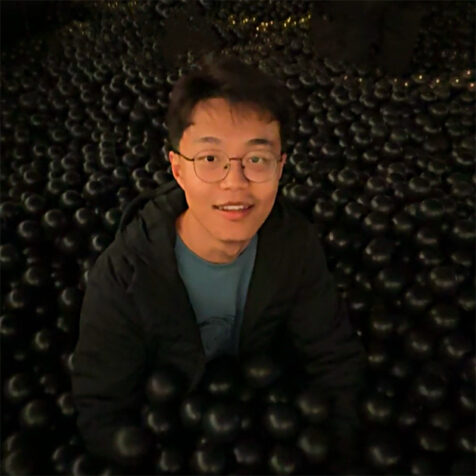 man with glasses smiling looks at camera